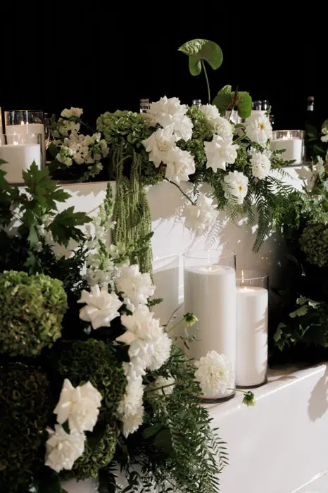 Reception table flowers with candles and white green florals