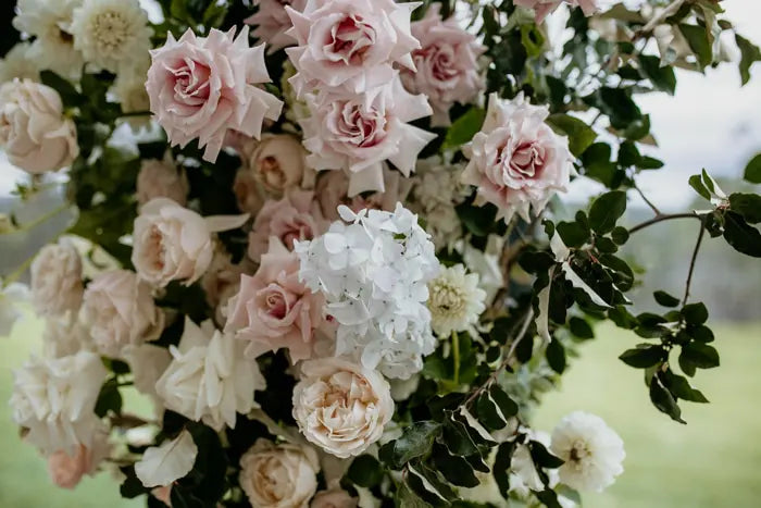 Close up of blush roses and ivory wedding flowers