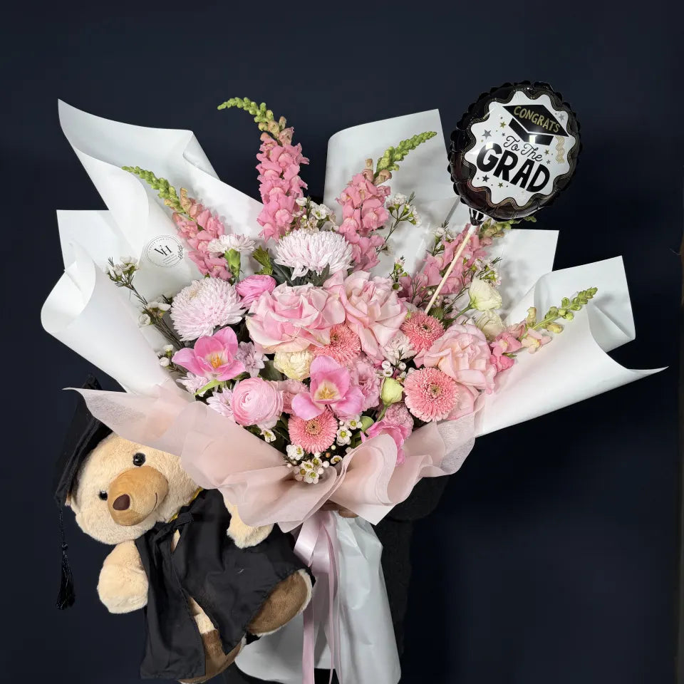 Pink graduation bouquet and cap-and-gown teddy gift photographed together for a Sydney graduation celebration.