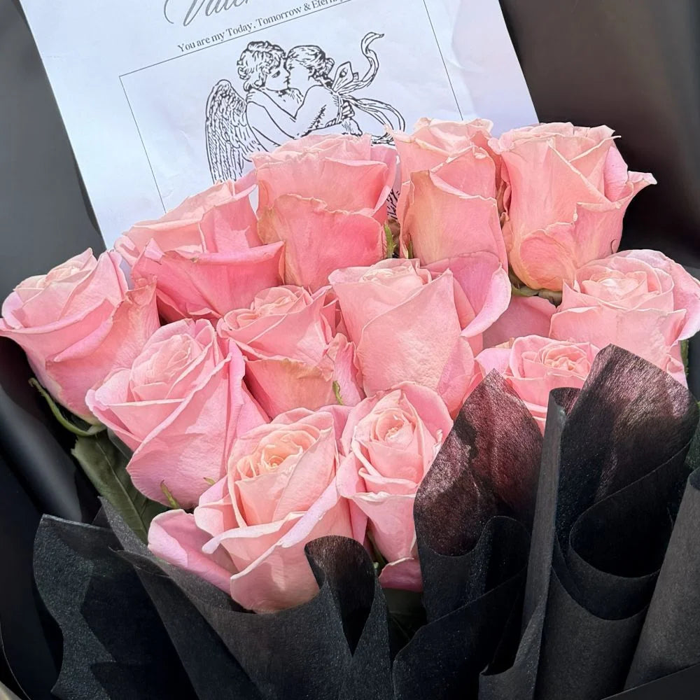 Close-up of 12 blush pink roses bouquet in black paper wrap with romantic gift card, Sydney same-day luxury pink rose delivery by Vhouse Florist