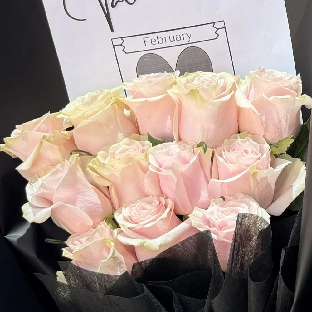 Close-up of 12 pale light pink roses bouquet in black paper with romantic gift card, Sydney same-day luxury light pink rose delivery by Vhouse Florist