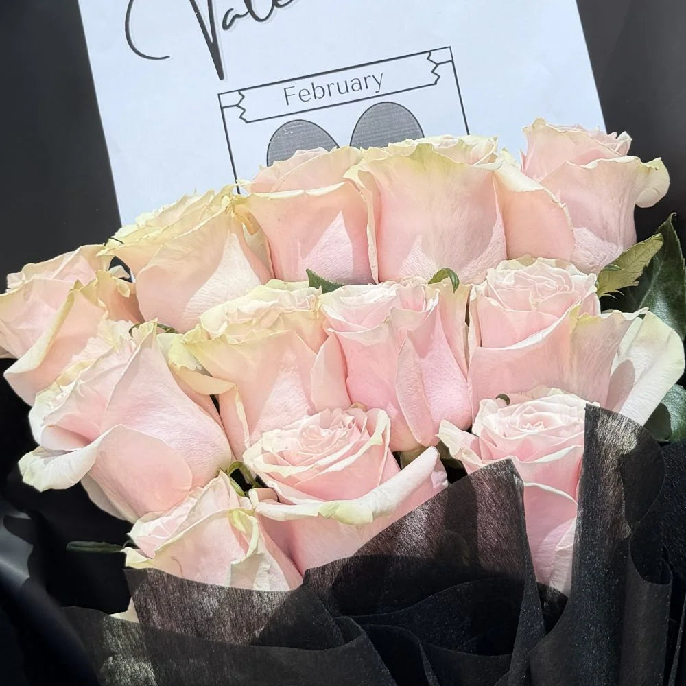 Close-up of 12 light pink roses bouquet in black paper wrap with romantic gift card, Sydney same-day luxury light pink rose delivery by Vhouse Florist