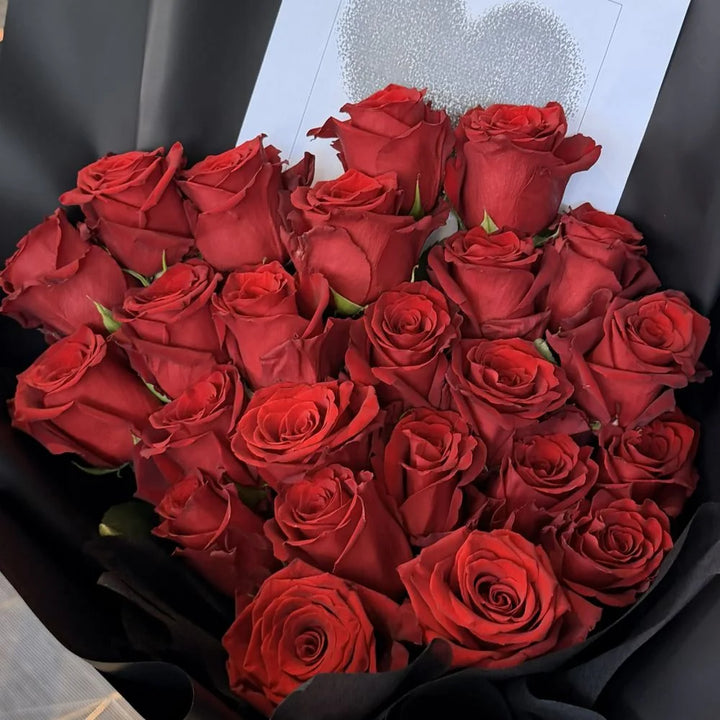 Close-up detail of 24 luxury red roses bouquet wrapped in black paper with romantic gift card, Sydney same-day luxury red rose delivery by Vhouse Florist