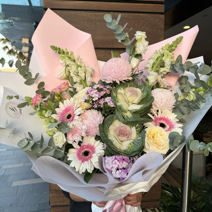Luxury pink bouquet with gerberas, ornamental kale, pink chrysanthemums, roses and eucalyptus wrapped in pink paper, Sydney same-day luxury flower delivery by Vhouse Florist