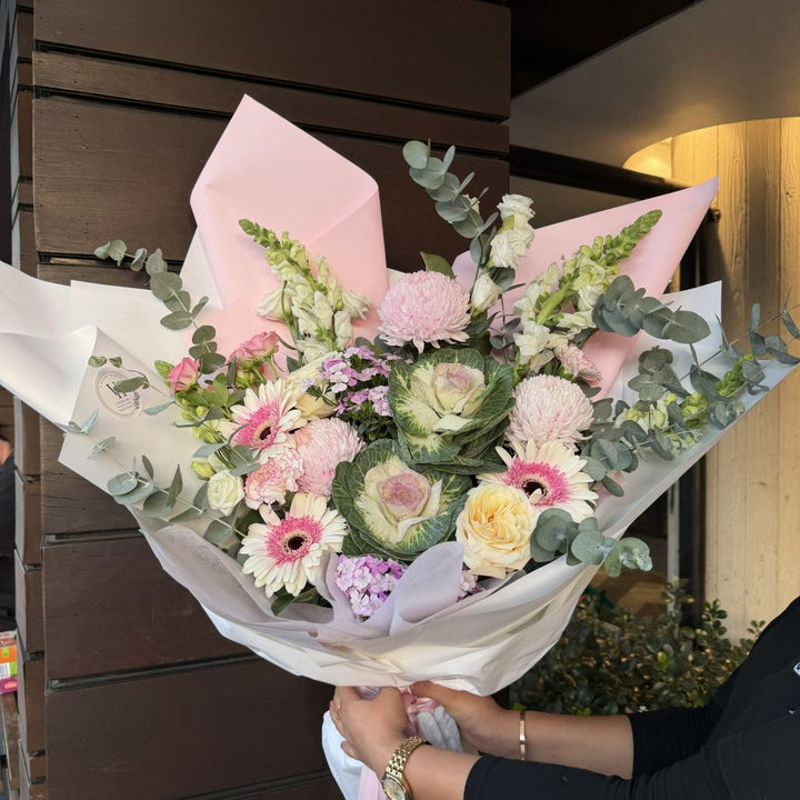 Luxury pink bouquet with gerberas, ornamental kale, roses, snapdragons and eucalyptus wrapped in pink paper, Sydney same-day luxury flower delivery by Vhouse Florist