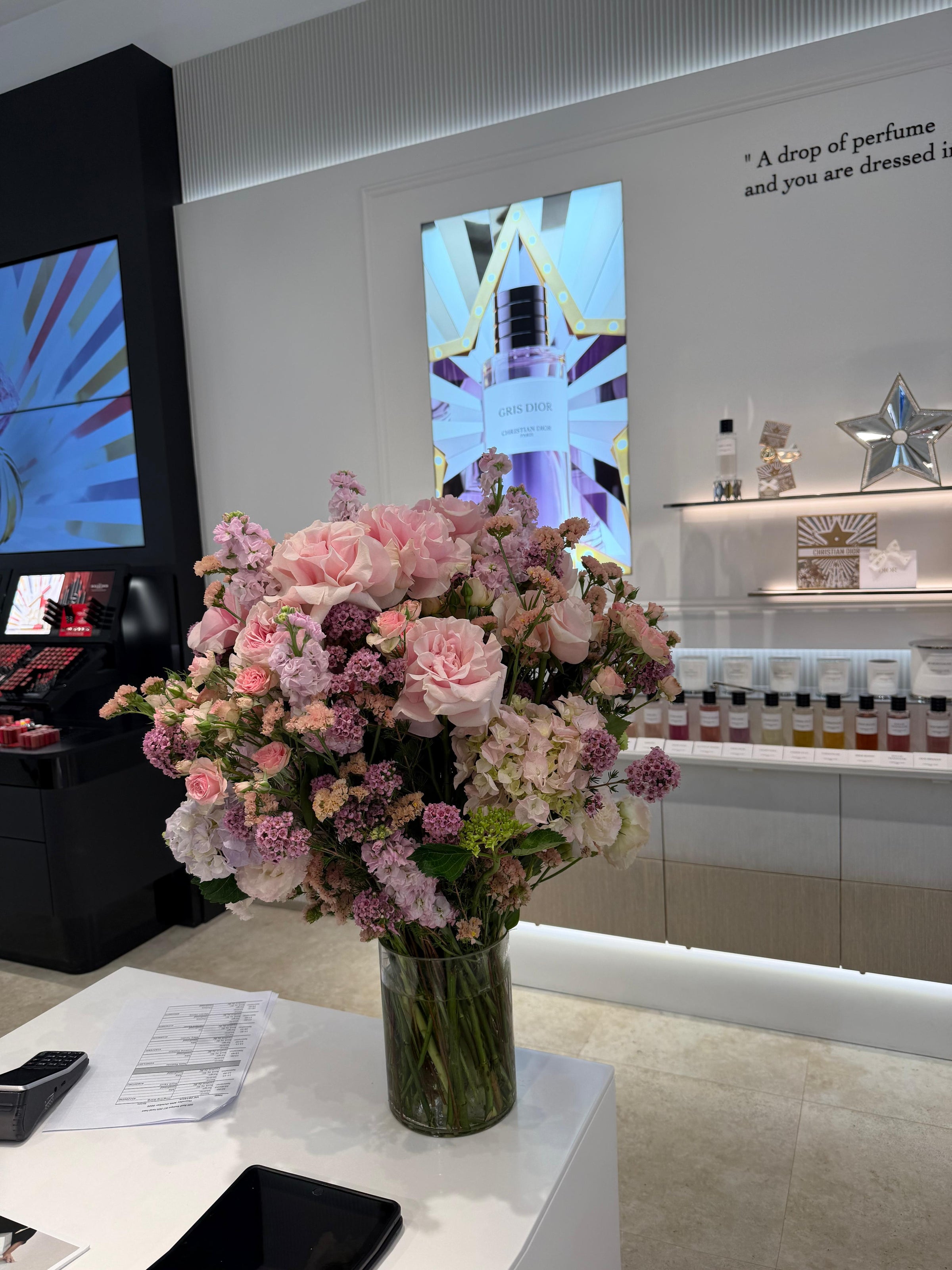 Blush pink rose and hydrangea floral arrangement on Dior boutique counter with J'adore perfume display and 'A drop of perfume and you are dressed in Dior' quote, Dior beauty event flowers and corporate event flowers Sydney by Vhouse Florist