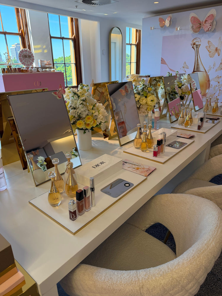 Dior beauty makeup station with mirrors, Dior cosmetics and white rose floral arrangements with butterfly decor, Dior beauty event flowers and corporate event styling Sydney by Vhouse Florist