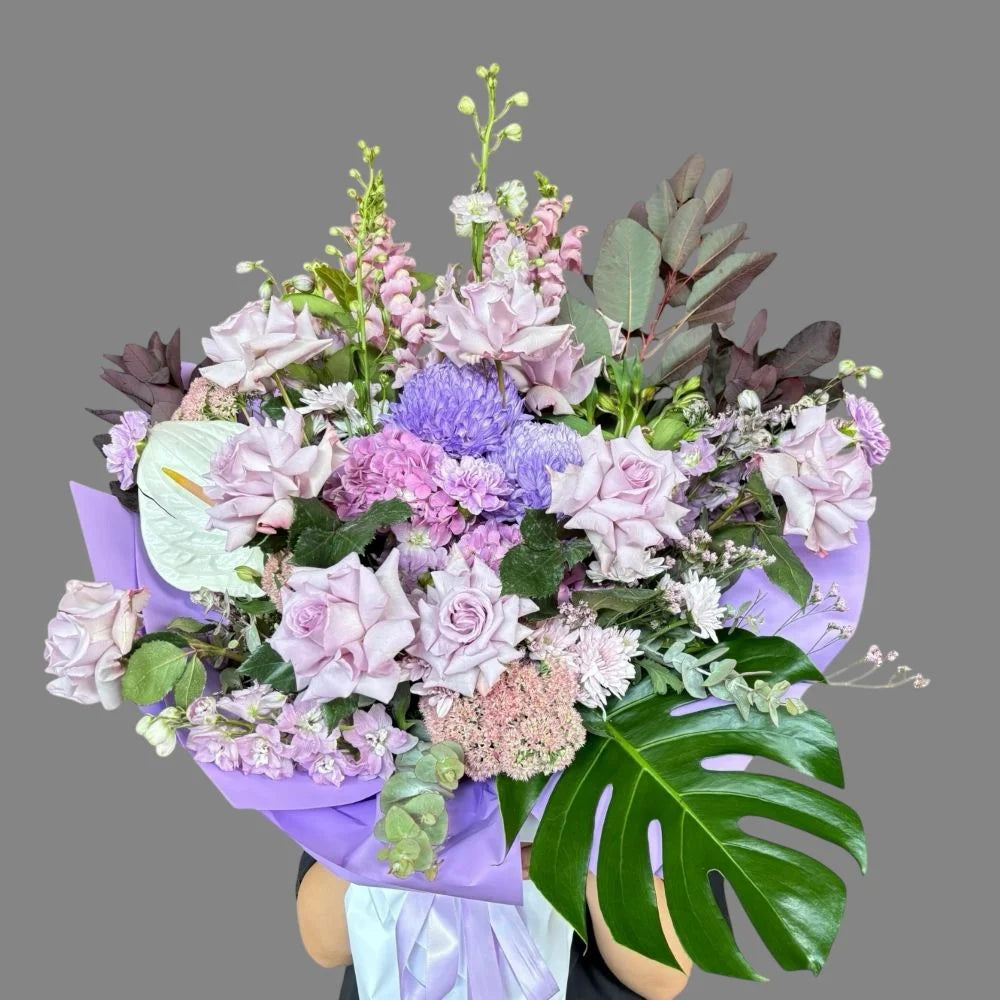 Amethyst Love grand luxury bouquet with lavender roses, blue chrysanthemums, snapdragons, lisianthus and monstera leaves in purple wrap, Sydney luxury flower delivery by Vhouse Florist
