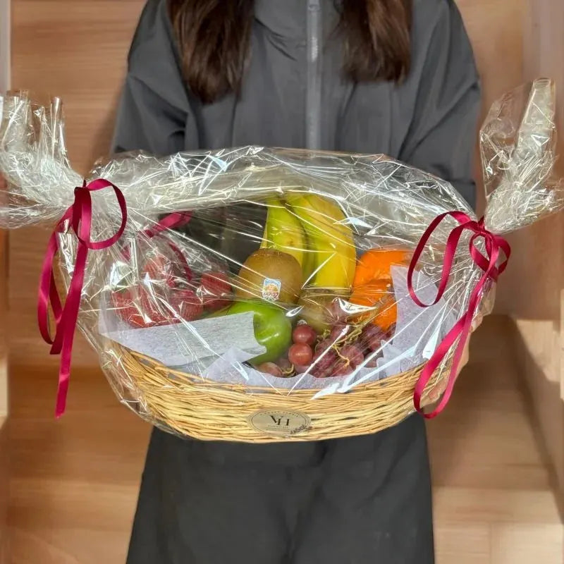 Assorted fruit basket of oranges, green apples, red grapes, kiwi, strawberries and bananas, hand-held view