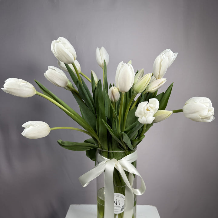 Ivory white tulips in a glass vase