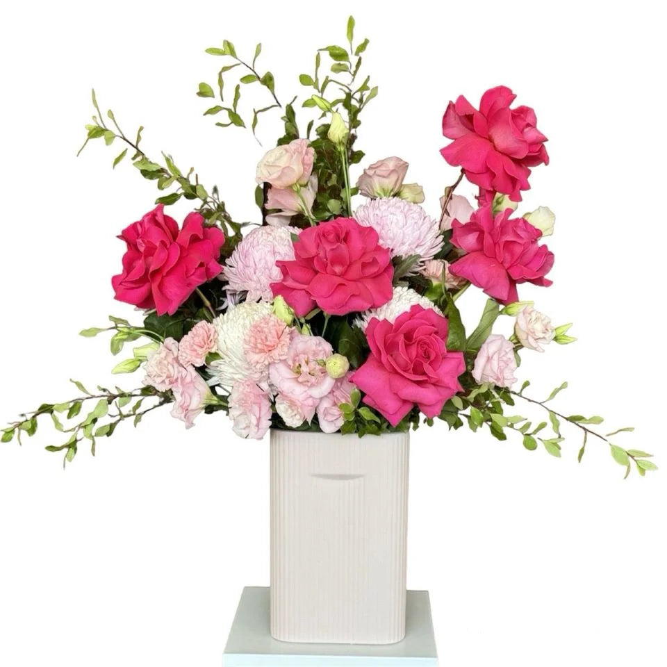 Pink roses and light Pink Flowers with greenery in white straight ceramic vase, front view