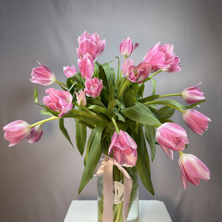 Vivid hot pink tulips in a glass vase