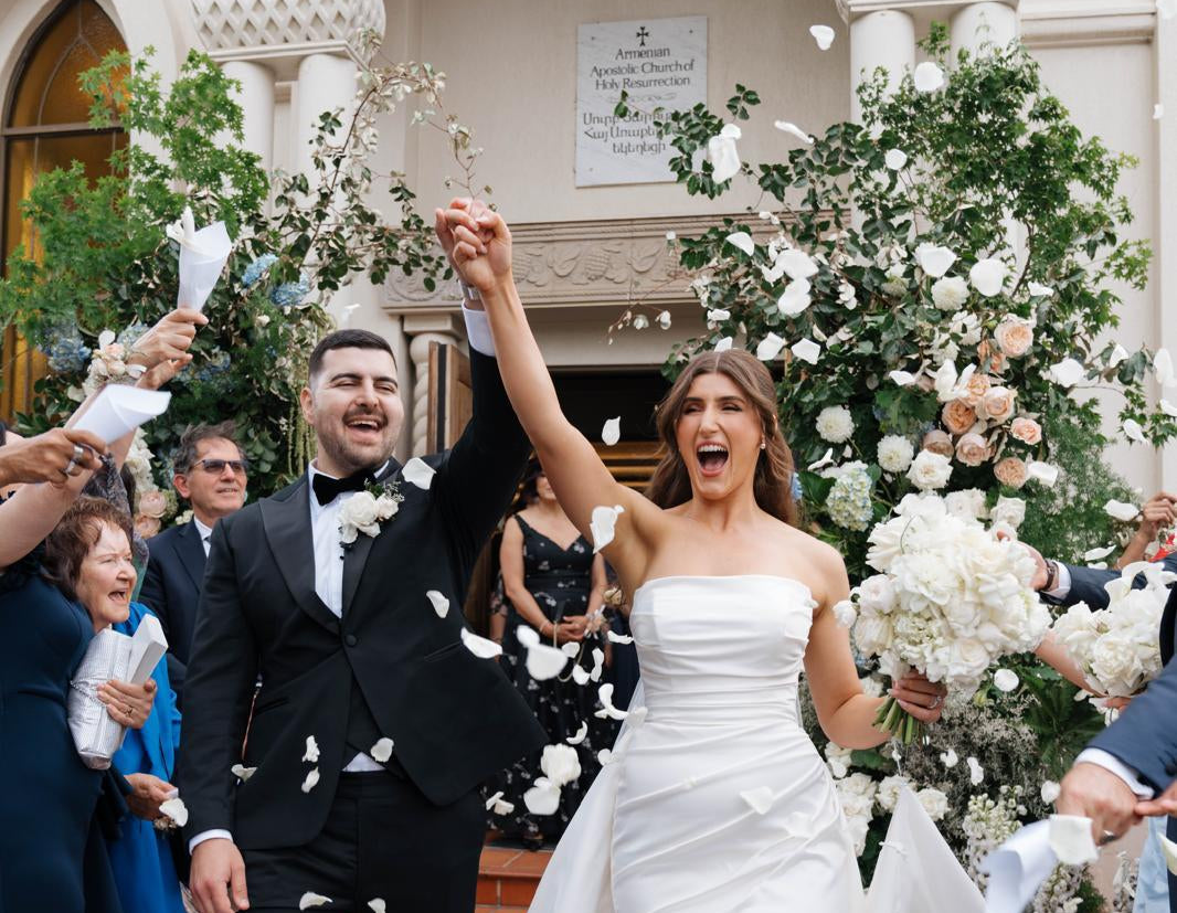 Wedding couple celebrating beside Vhouse Florist floral installation