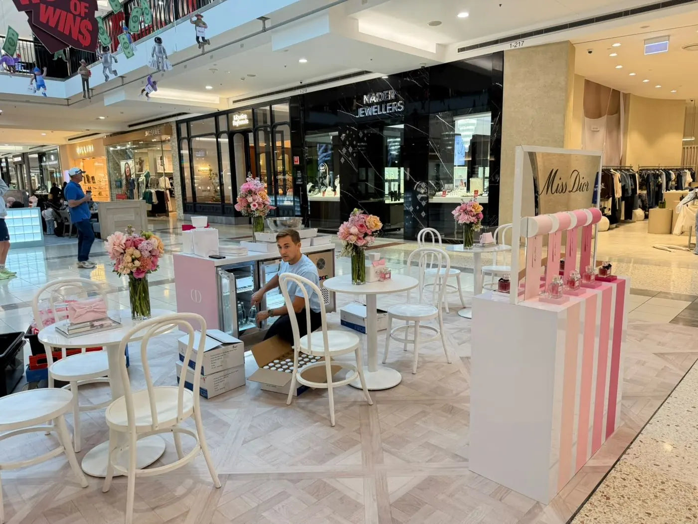 Brand activation flowers for a Miss Dior fragrance pop-up in a Sydney shopping centre, with pink and peach arrangements on every table
