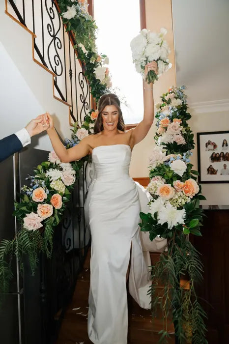 Bride with modern white bouquet on staircase