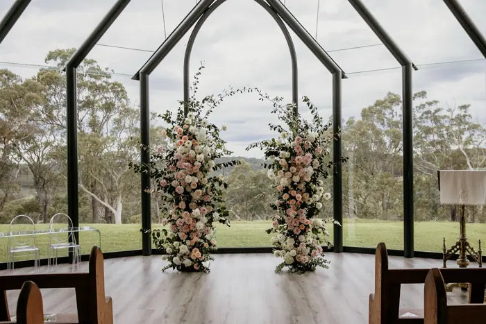 Soft blush and ivory ceremony flowers inside a chapel