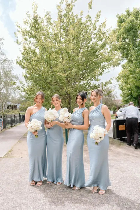 Bridesmaids holding soft blue and white bouquets