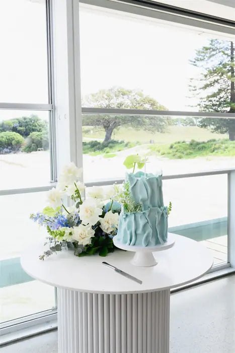 Christening flowers with blue cake and soft floral styling